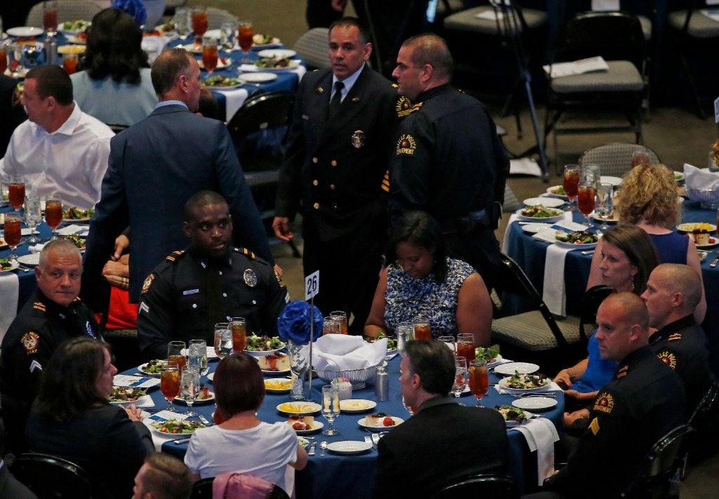 Officers and their families gather during the awards ceremony at American Airlines Center in...