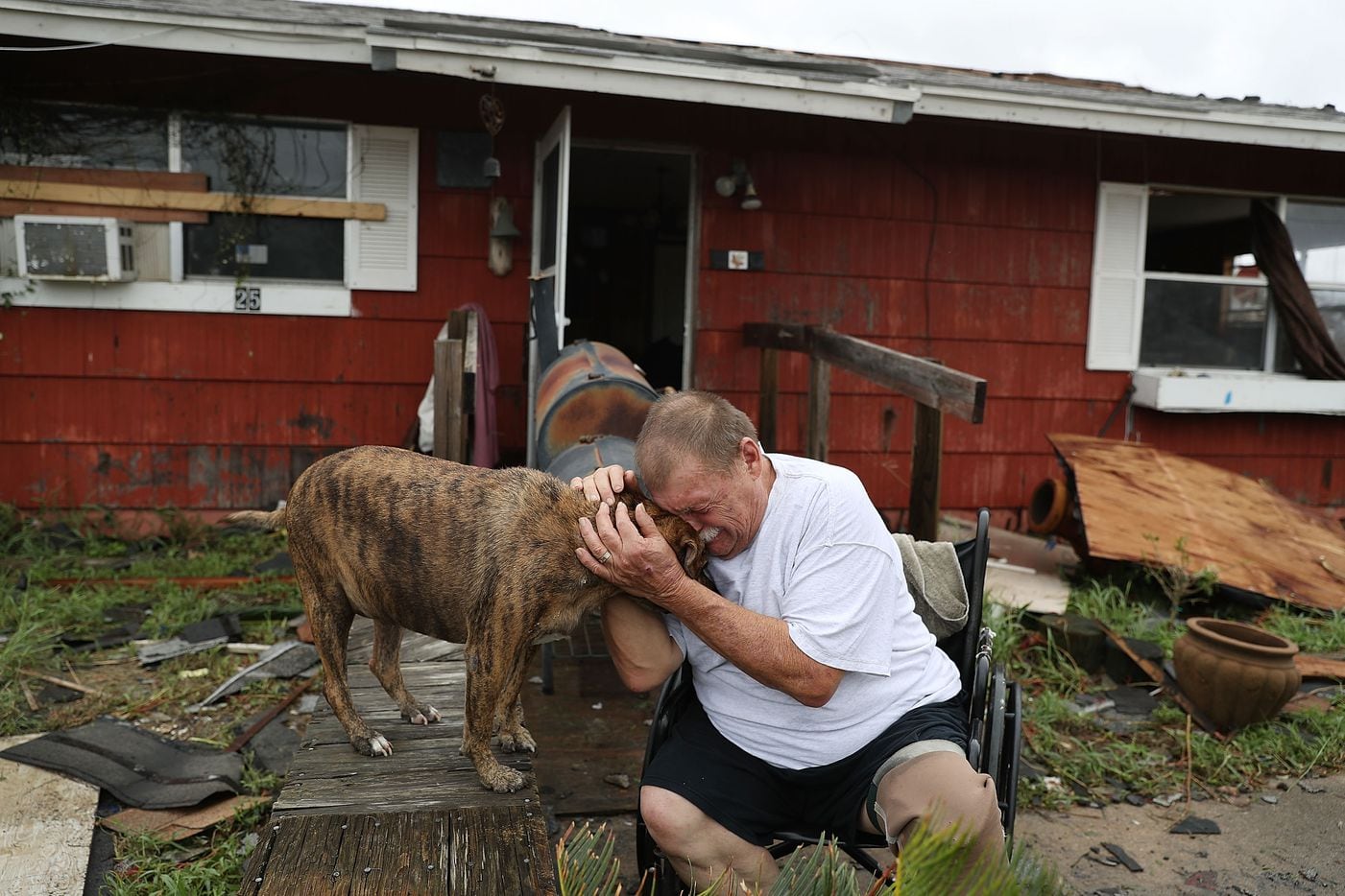 Steve Culver cries with his dog Otis as he talks about what he said was the, "most terrifying event in his life," when Hurricane Harvey blew in and destroyed most of his home while he and his wife took shelter there on Saturday in Rockport.