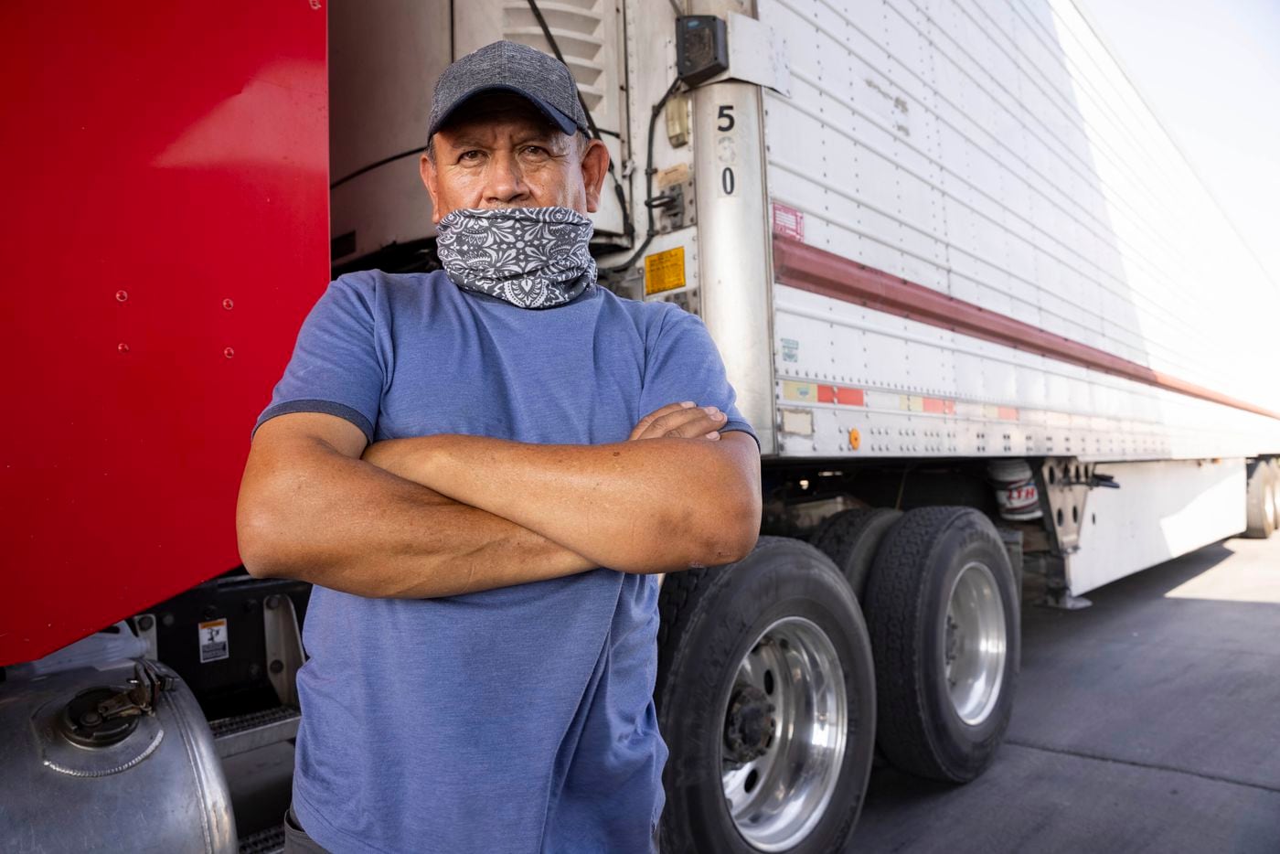 Truck driver Bonifacio Rodríguez poses for a photo in front of his truck as he waits at...