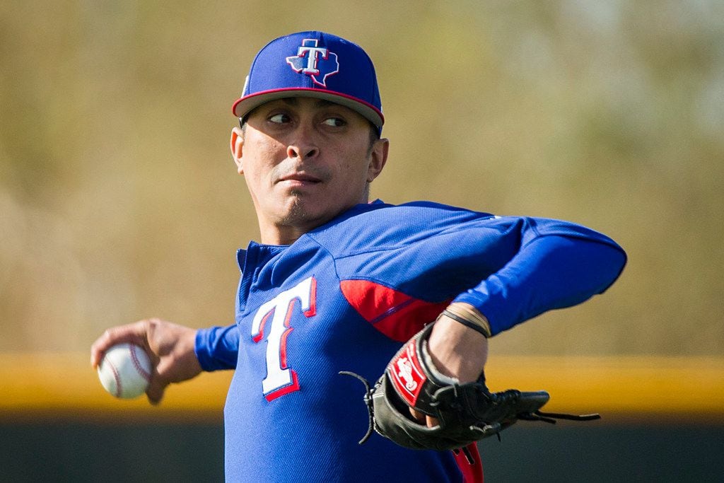 Texas Rangers pitcher Jesse Chavez plays catch during a spring training workout at the...