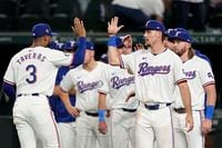 Texas Rangers' Leody Taveras (3) and Evan Carter, front right, celebrate with teammates...