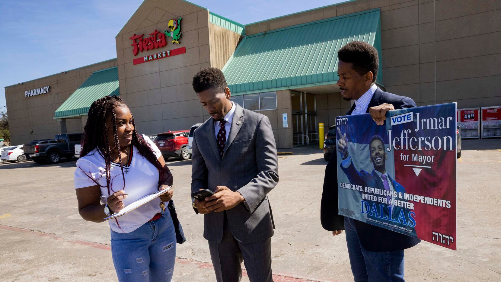 Jrmar Jefferson (center) and twin brother Lamar Jefferson (right) talk with a voter outside...
