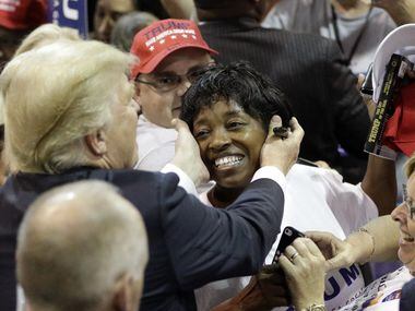 Republican presidential candidate Donald Trump reaches out to hug a supporter after a rally...