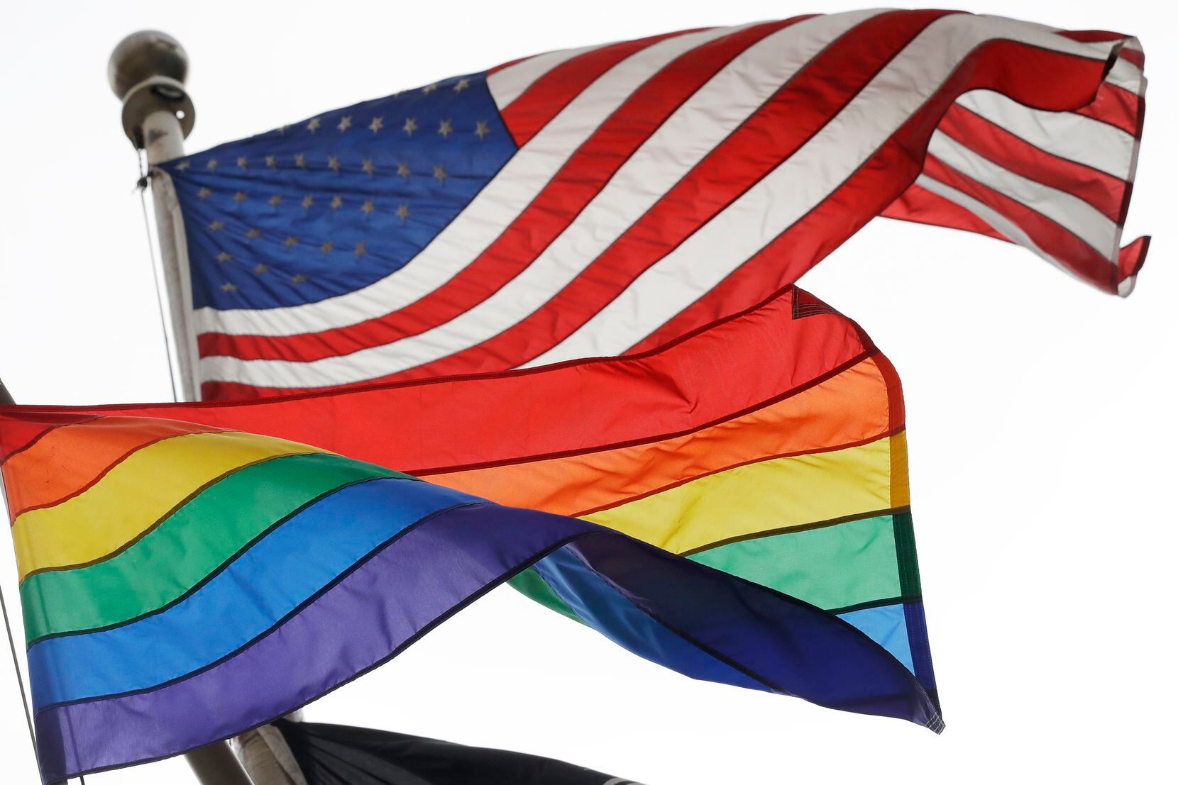The U.S. flag and the rainbow flag, an international symbol of LGBTQ liberation and pride,...