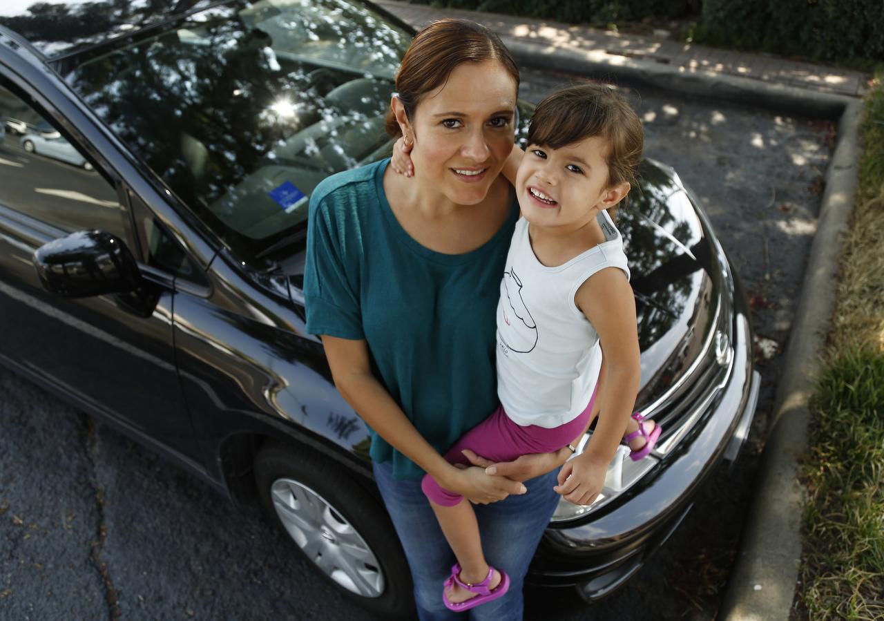 
Waitress Yasmin Flores, with her daughter, Yvette, says her car frees her from a bus that...