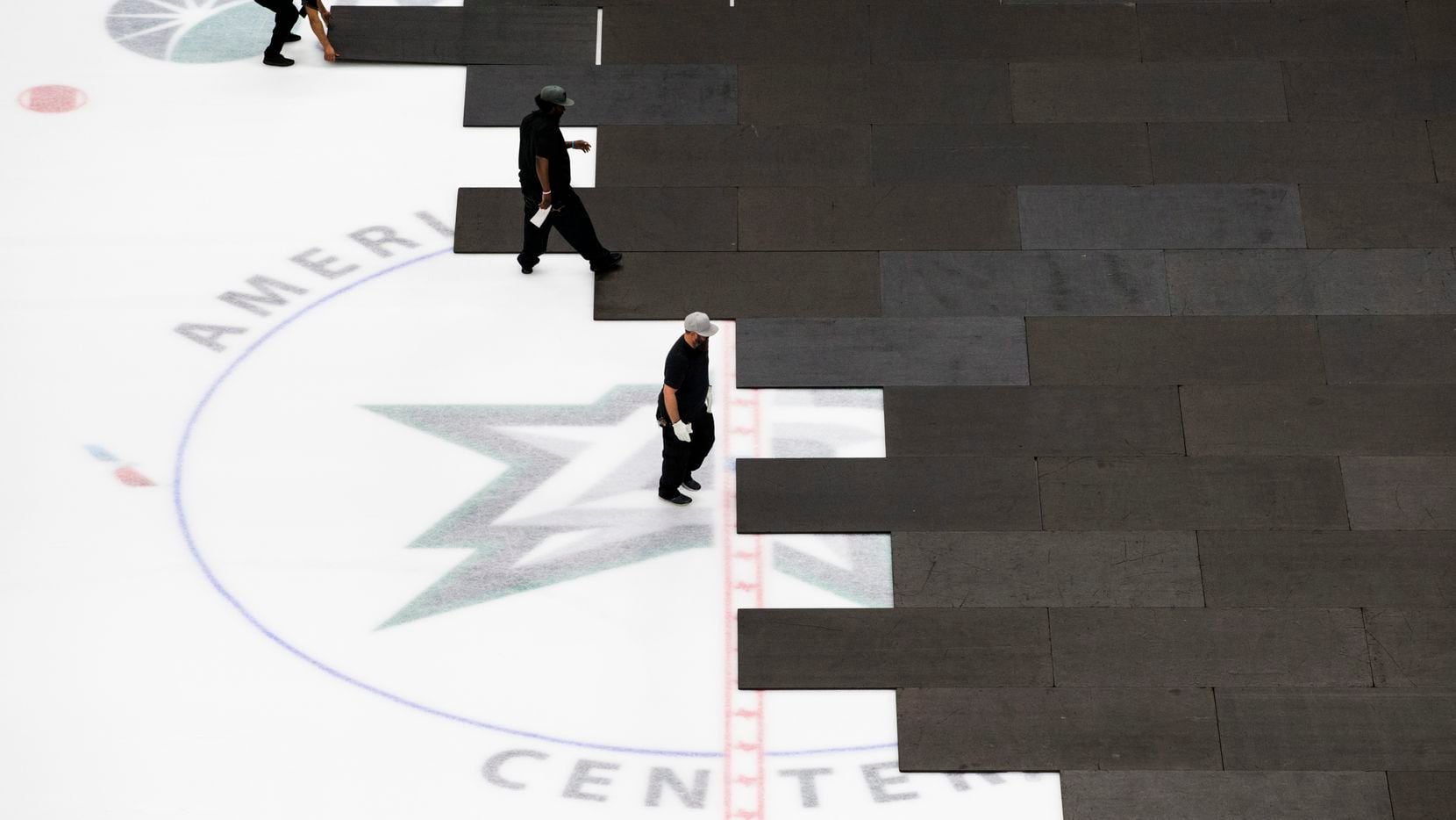 Crews cover the Dallas Stars ice after the NHL season was put on hold due to coronavirus on...