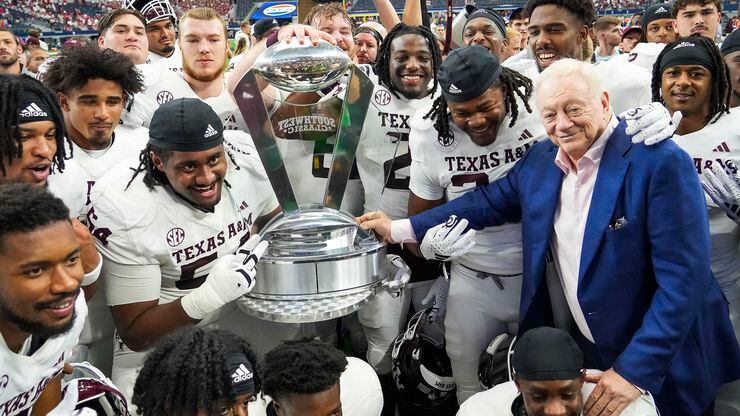 Dallas Cowboys owner and general manager Jerry Jones poses with Texas A&M players after the...