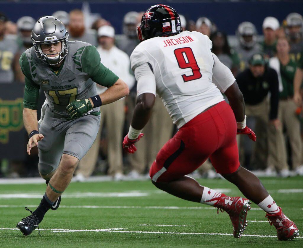 Baylor Bears quarterback Seth Russell (17) blocks Texas Tech Red Raiders defensive lineman Branden Jackson (9) after handing the ball of in the third quarter during an NCAA football game between Texas Tech and Baylor at AT&T Stadium in Arlington, Texas Saturday October 3, 2015. (Andy Jacobsohn/The Dallas Morning News)