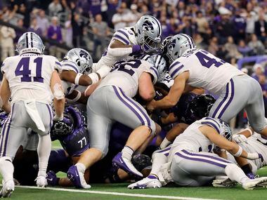 TCU Horned Frogs running back Kendre Miller (33) is buried by the Kansas State Wildcats...