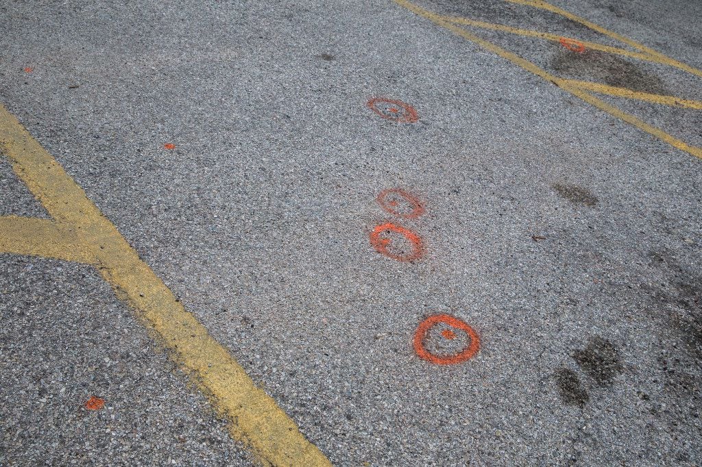 Orange spray painted circles mark where shell casings were recovered near the intersection...