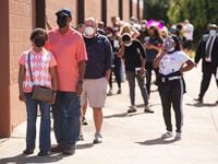 Voters wait in line during the first day of early voting at the South Garland Branch Library in October 2020.
