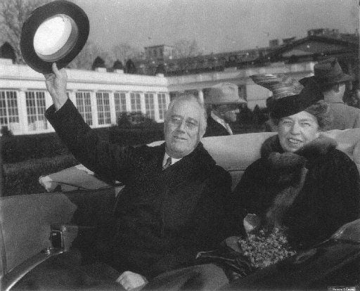Franklin Delano Roosevelt and his wife Eleanor Roosevelt are seen in the back seat of an...