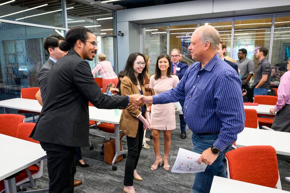 AT&T's vice president for data science Mark Austin shakes hands with a Southern Methodist...