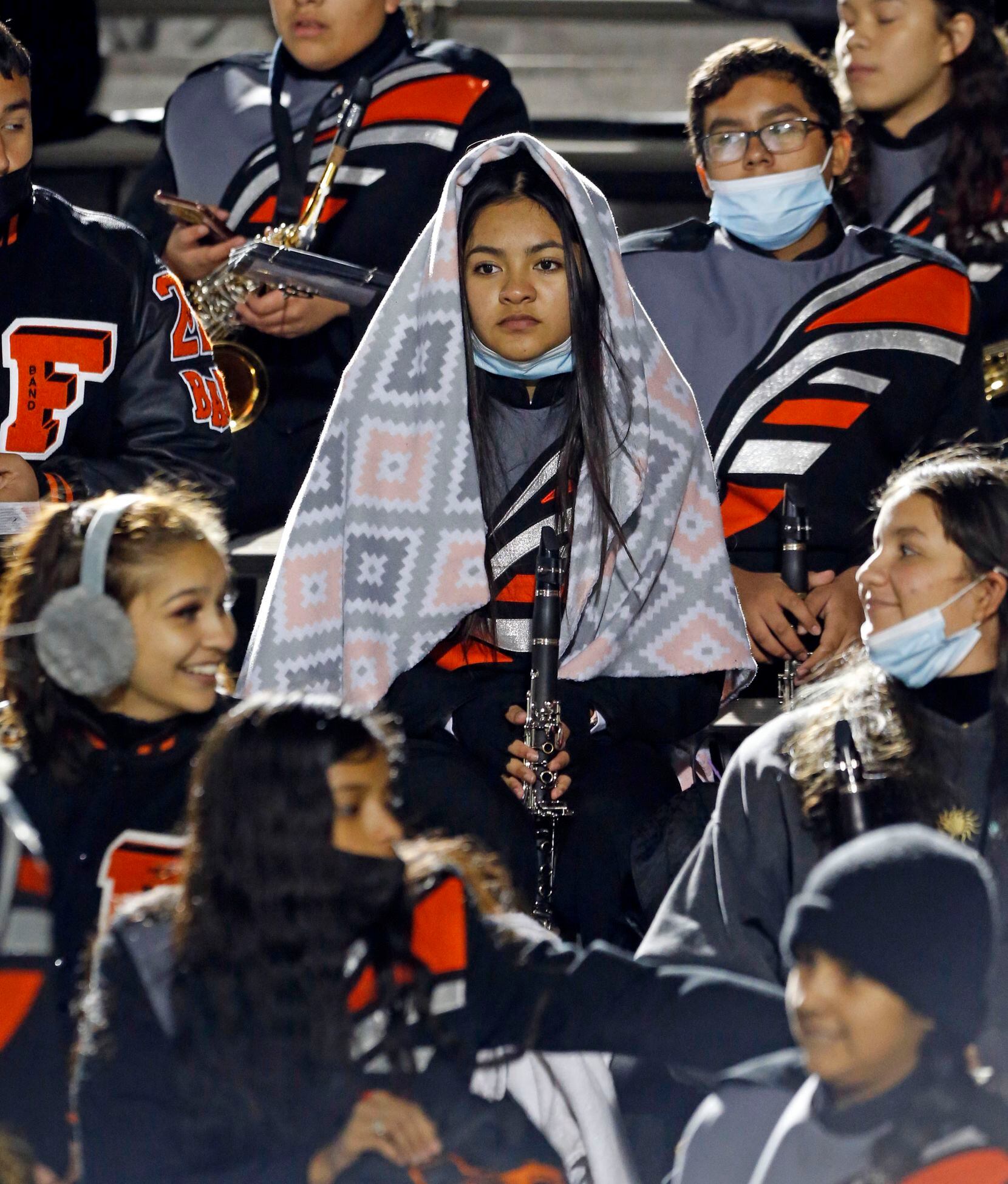 A Ferris High band member looks like a Madonna, as he covers up from the evening chill with...