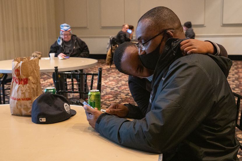 Chidi Anorue, 8, gives dad Patrick Anorue a hug at the warming center located at Ruthe...