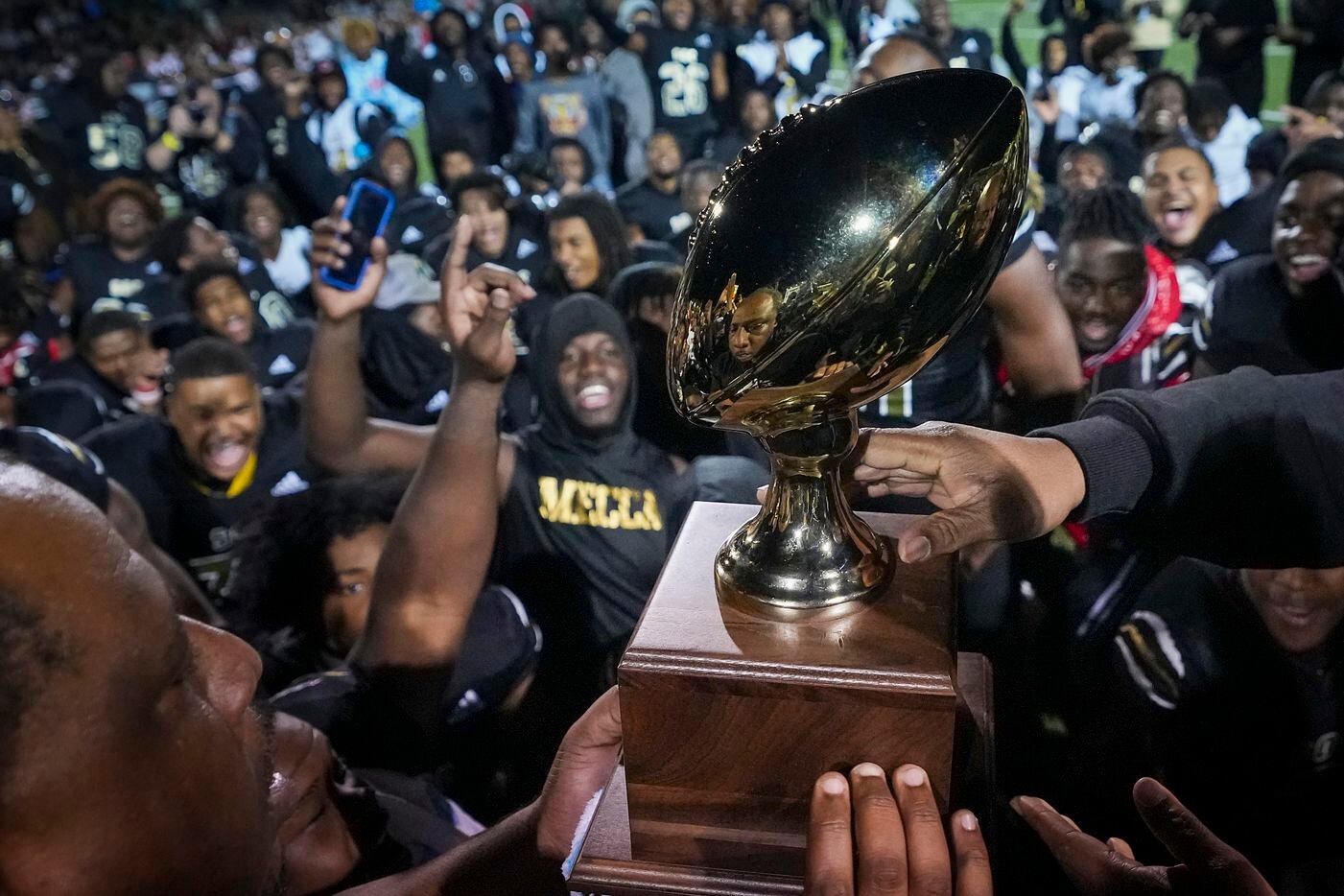 South Oak Cliff head coach Jason Todd lifts the game trophy after a victory over Lubbock...