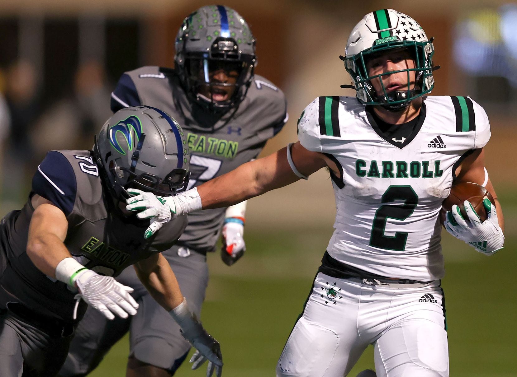 Southlake Carroll running back Owen Allen (2) gives a stiff arm to Eaton safety Aric Wood...