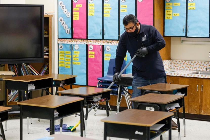 Custodian Joe Gomez mops a classroom floor at Rayburn Elementary STEAM Academy in Grand...