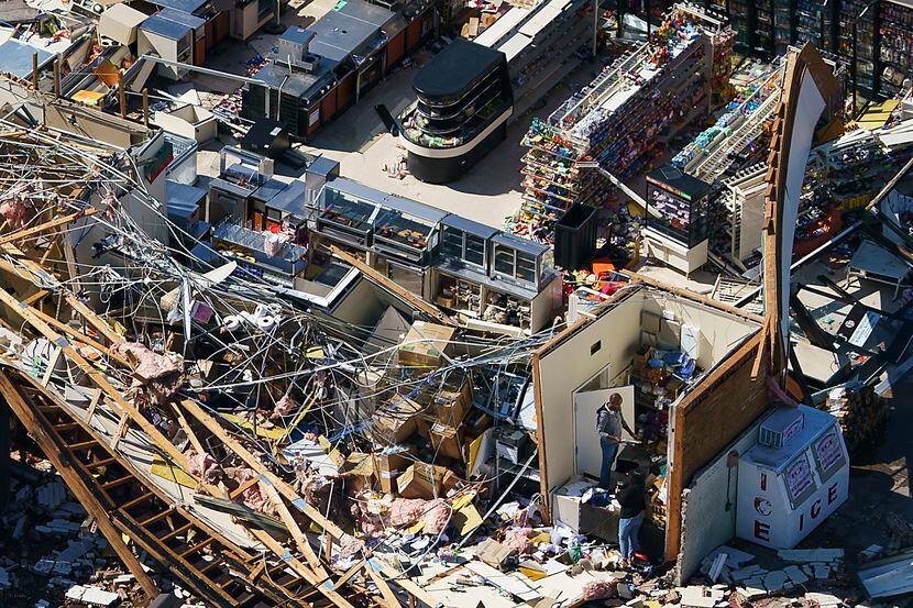 People pick through the rubble of a 7-Eleven store on Walnut Hill near Harry Hines on...