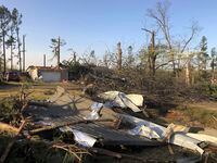 Debris covers the ground around a home that was damaged from severe weather in Wynne, Ark.,...