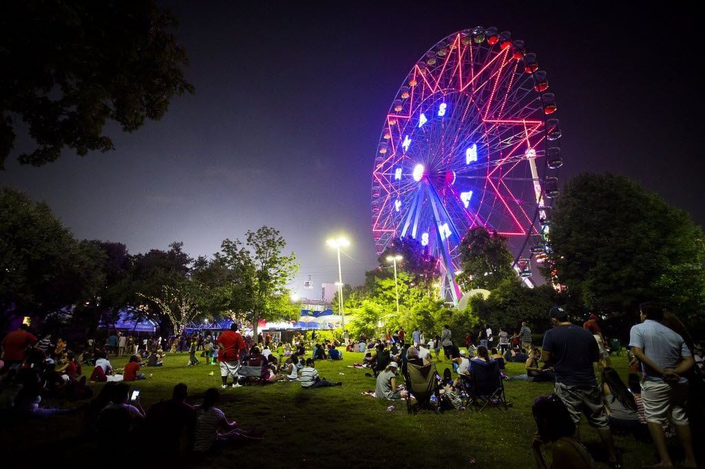 Spectators waited for the fireworks show to begin near the Texas Star ferris wheel during...