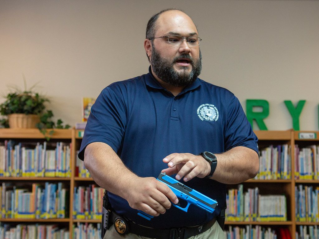 Michael Antu, the Director of Enforcement and Special Services handles a gun that shoots simulated ammunition while talking to the media about what the student school marshals will be using when they perform practice drills during one of the trainings at Windermere Elementary School in Pflugerville, Texas on August 10, 2018. (Thao Nguyen/Special Contributor)
