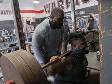 Homicide Sergeant Brian Jones (left) from the Arlington Police Department spots for Arlington Martin Defensive tackle Marquis Evans during their workout at the school's gym as part of the "Coach 5-0" program on Monday, Sept. 21, 2020 in Arlington.