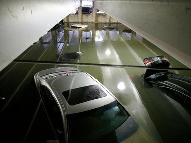 Flooded cars parked in the lower level of parking garage A at Dallas Love Field under water...