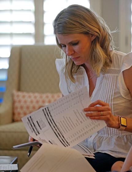 Kasey Woleben looks at a medical bill in the living room at her home in McKinney, Texas,...