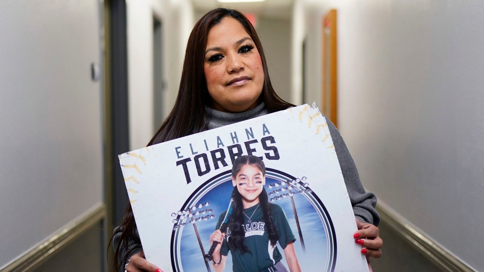 Sandra Torres, muestra un cartel con la foto de su hija Eliahna, una de los 19 niños y dos...