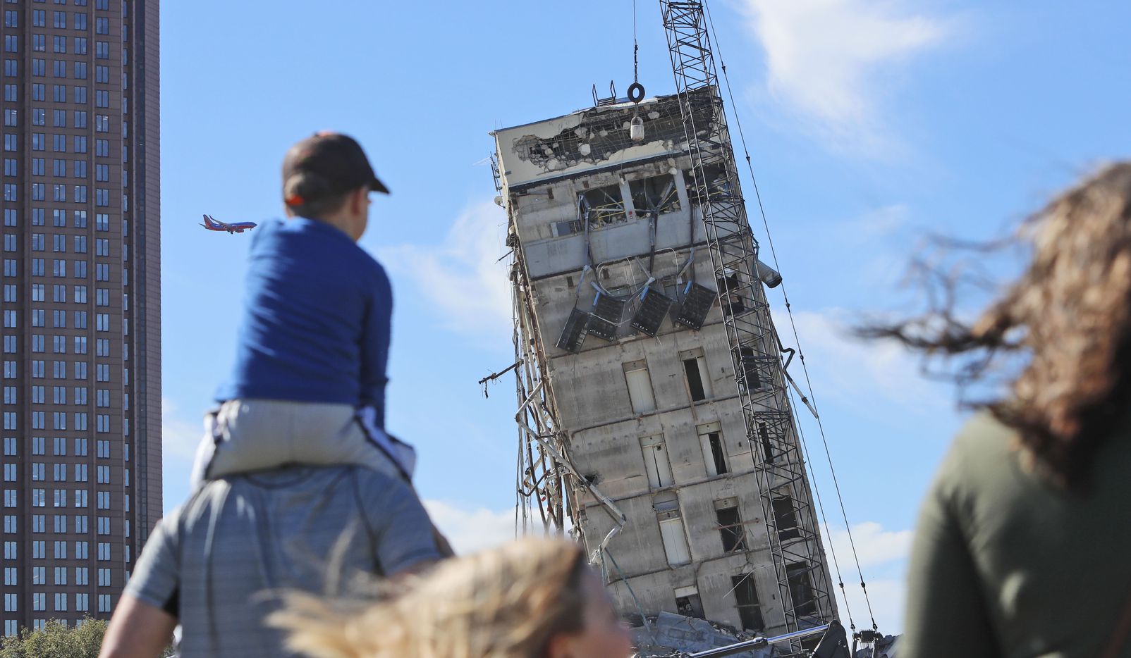 People gather to watch the demolition of the so called "Leaning Tower of Dallas" as a...