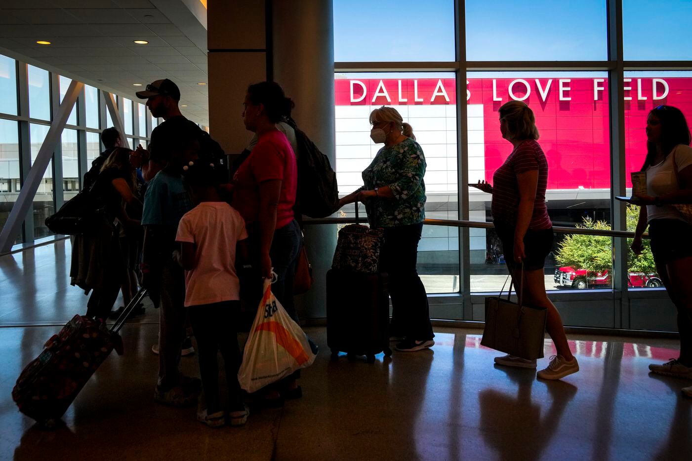 Passengers wait to reenter Dallas Love Field Airport on Monday, July 25, 2022.  A ground...