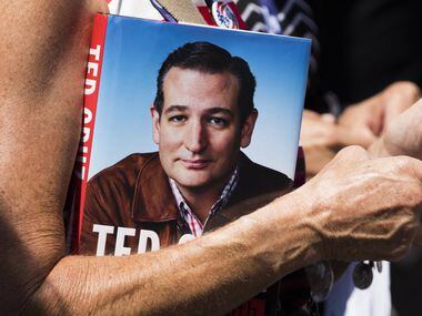 A supporters holds a copy of his book while waiting in line for the doors to open for a Ted...