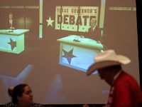 Supporters of Texas Gov. Greg Abbott watch his debate with Texas Democratic gubernatorial...