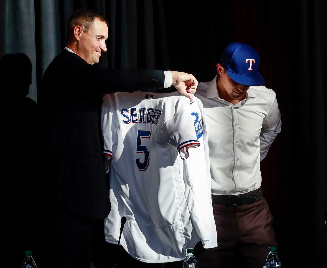 Corey Seager puts on his jersey at a news conference at Globe Life Park in Arlington on...