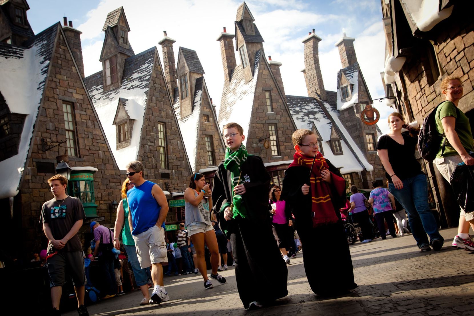 Visitors carry magic wands in the village of Hogsmeade at the Wizarding World of Harry...