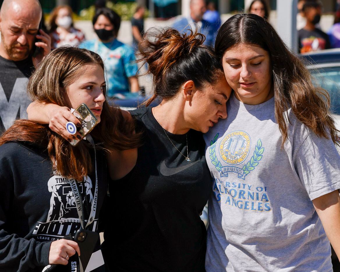 Liz Hasani (center) hugged her daughters Alivia (left) and Aminah outside the Mansfield ISD...