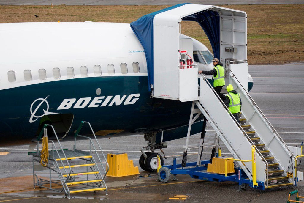 (FILES) In this file photo taken on March 12, 2019 workers are pictured next to a Boeing 737...