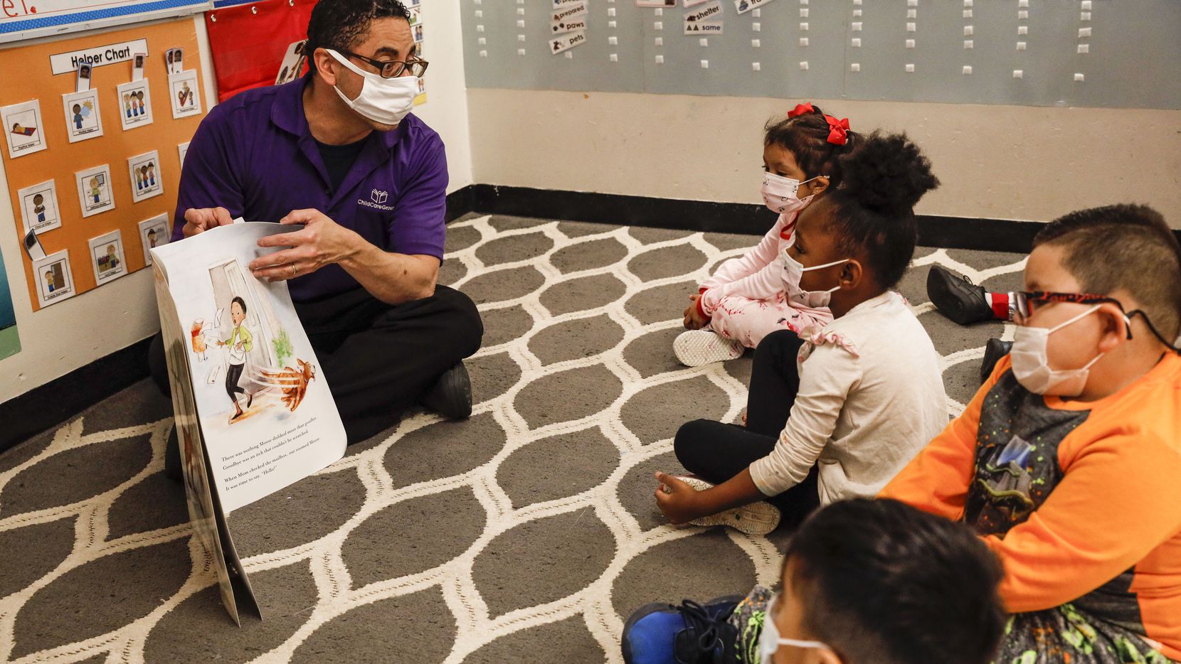 Juan Delgado, a preschool teacher at Child Care Group's Landauer Center, reads a book to...