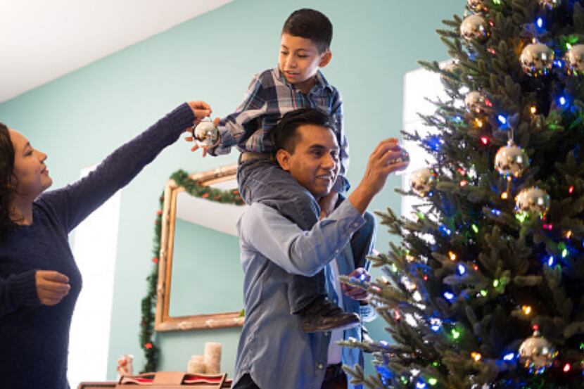 Una familia decora el árbol de Navidad.