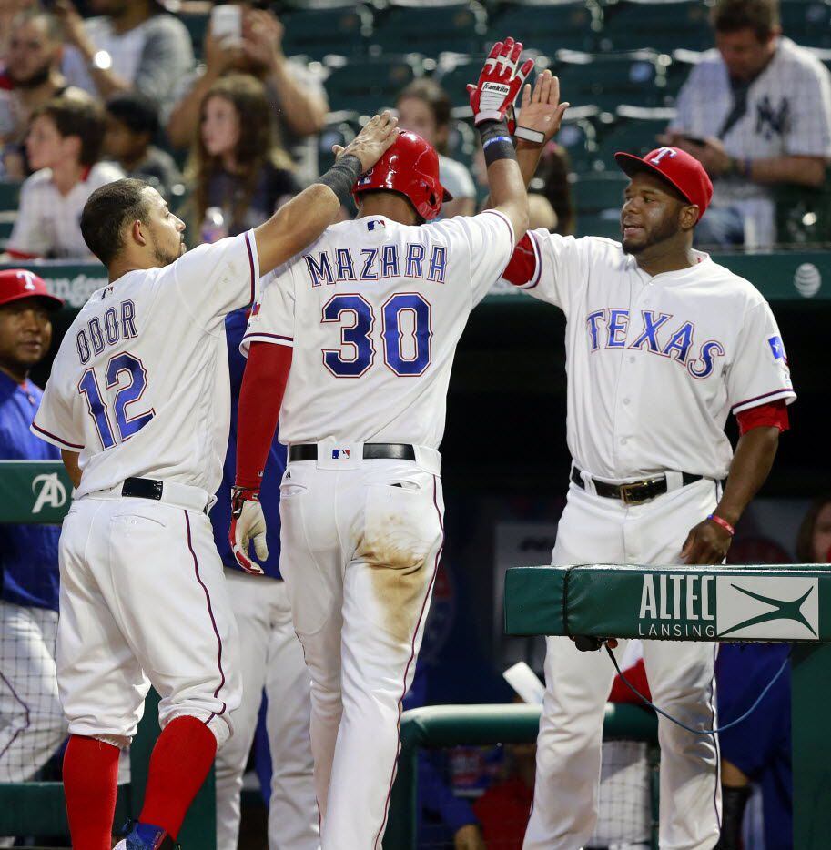 Texas Rangers right fielder Nomar Mazara (30) is greeted at the dugout by Texas Rangers...