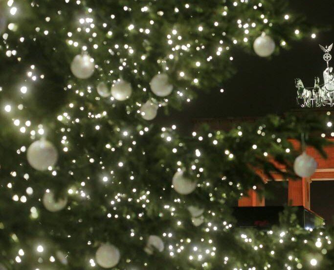 A Christmas tree stands in front of the Brandenburg Gate. 