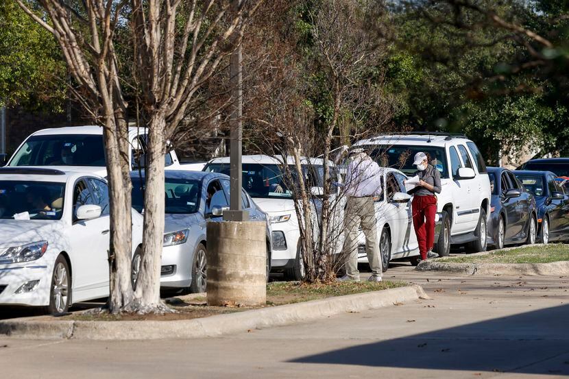 Dozens of people wait in their cars at a Neighborhood Medical Center COVID-19 testing...
