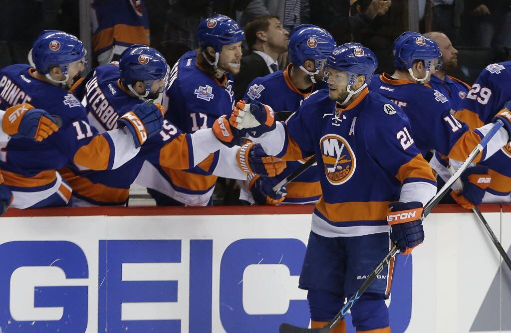New York Islanders right wing Kyle Okposo (21) is congratulated by teammates after scoring...