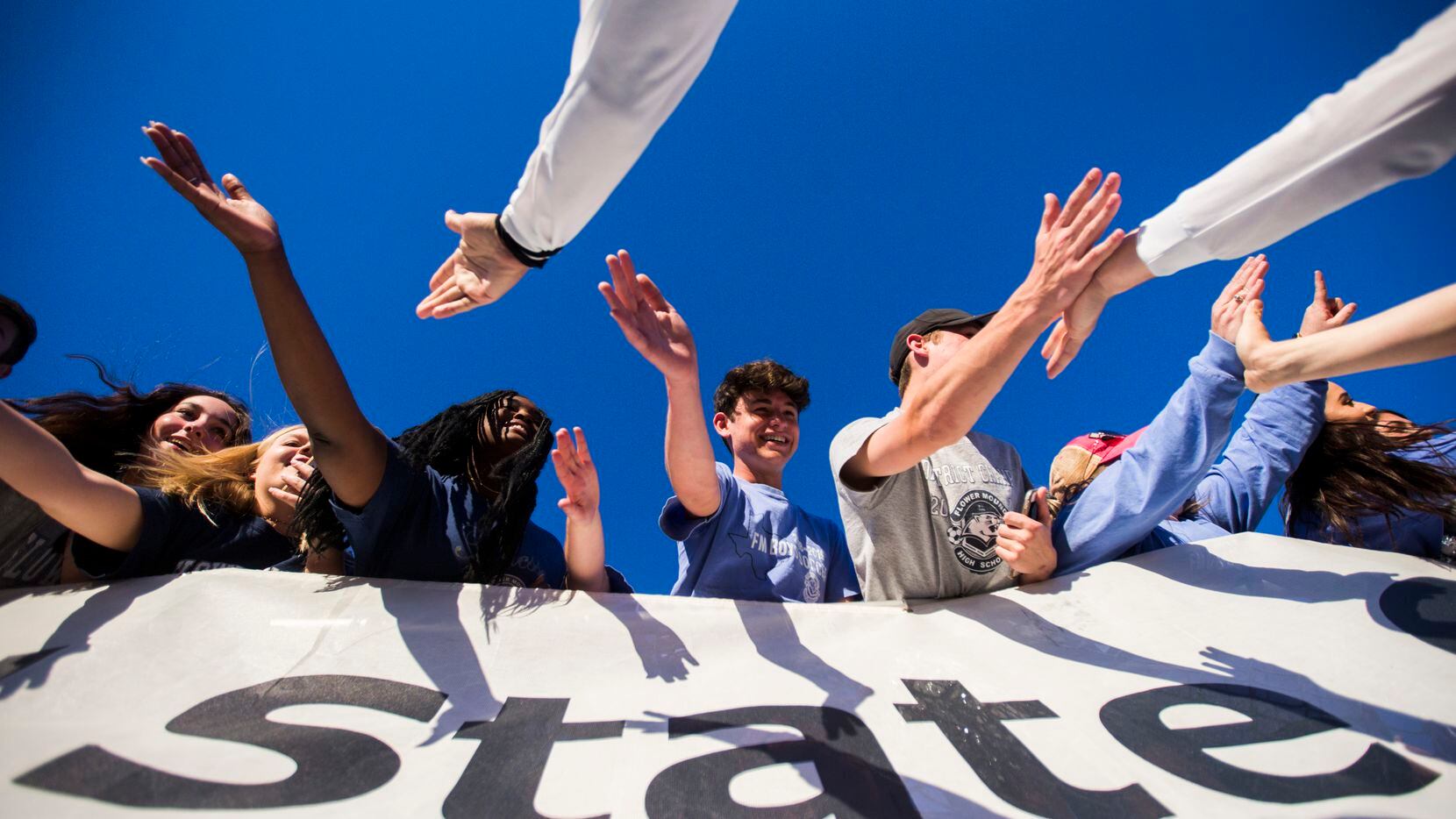 Flower Mound fans get high-fives from their soccer players after a 3-2 win in a UIL 6A boys...