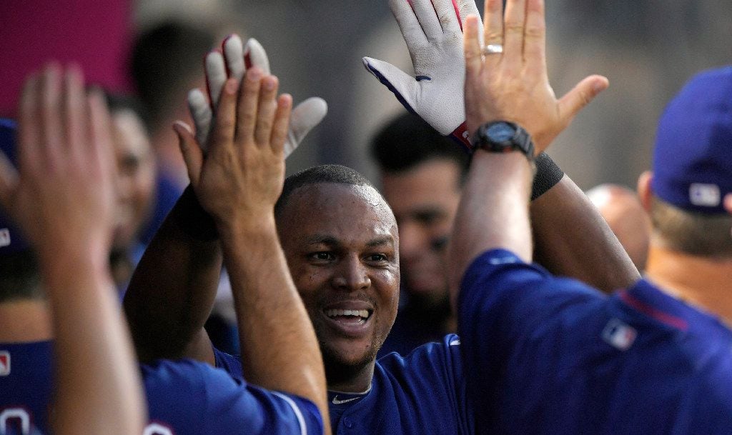 Texas Rangers' Adrian Beltre is congratulated by teammates after hitting a solo home run...