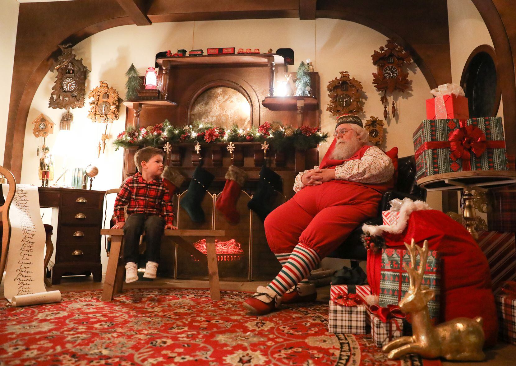 Fox Hoferer, 3, talks with Santa Claus about dinosaurs and his wish list during a visit to...