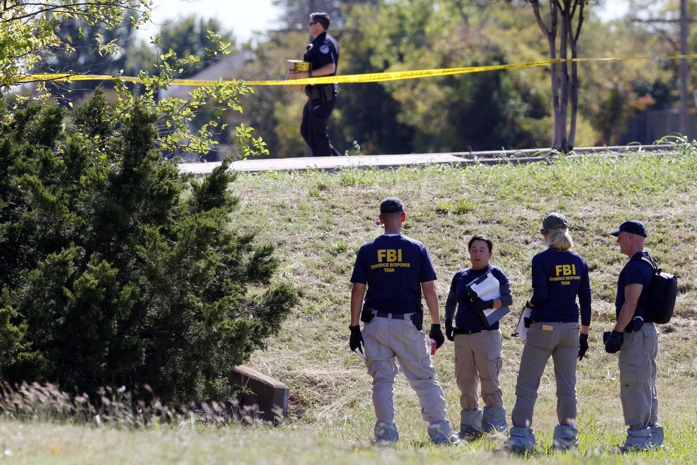 The FBI investigates an area near a culvert after a body of a child was found on Sunday,...