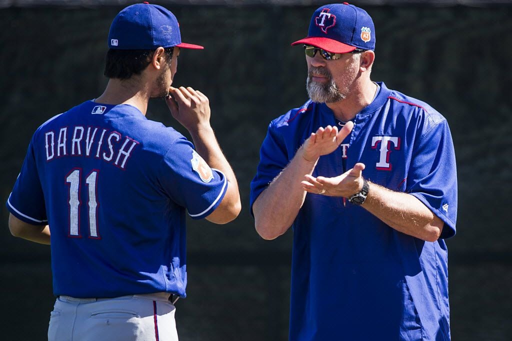 Texas Rangers pitcher Yu Darvish talks with pitching coach Doug Brocail after throwing in...