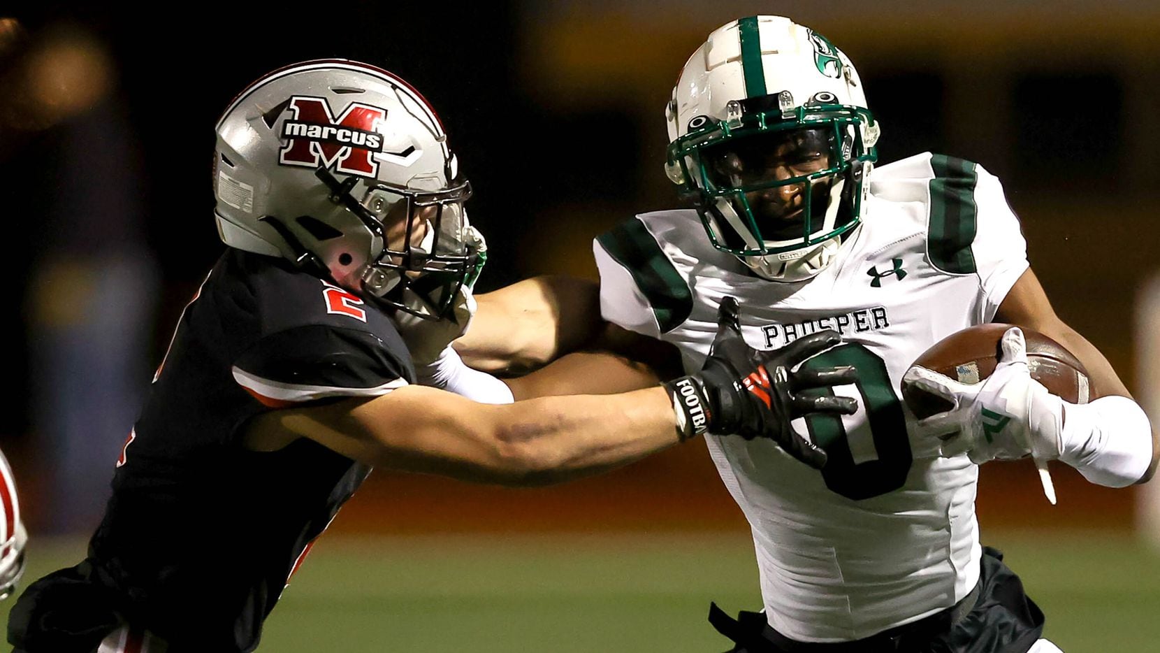 Prosper wide receiver Tyler Bailey (0) gives a stiff arm to Flower Mound Marcus defensive back Jake Ballard (2) during the first half in a Class 6A Division II bi-district high school football game played at Marcus Marauders Stadium, Friday, November 12, 2021, in Flower Mound. (Steve Nurenberg/Special Contributor)